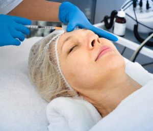 Female doctor doing beauty injection to mature woman client